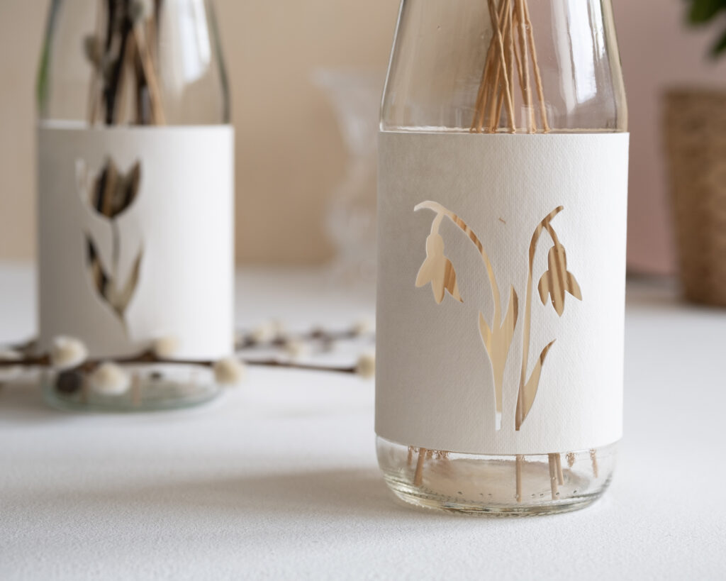 Die DIY upcycling Vase aus Altglas ist mit Trockenblumen befüllt und dient als Tischdeko