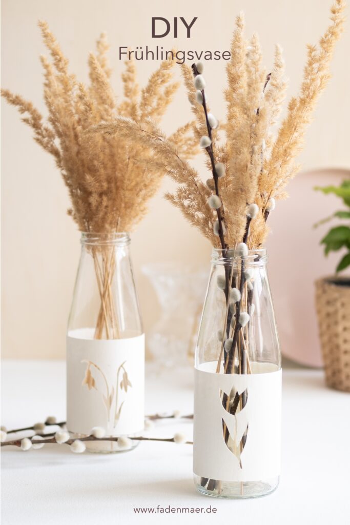 Die DIY upcycling Frühlingsvasen aus Altglas sind mit Trockenblumen und Weidenkätzchen befüllt und dienen als Deko auf einem Tisch